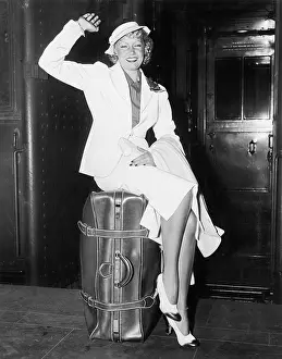 Getaway: A ready to go young woman sitting on her suitcase