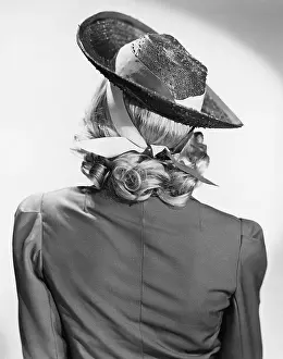 Poise: Rear view of a woman wearing a hat