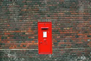 Letterbox: Red English Post Box in a brick wall