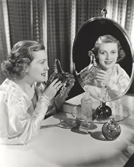 Atomizer: Reflection of woman holding perfume atomizer in mirror