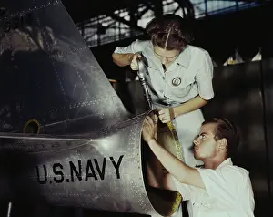 Repairing: A riveter supervises a NYA trainee at a U.S