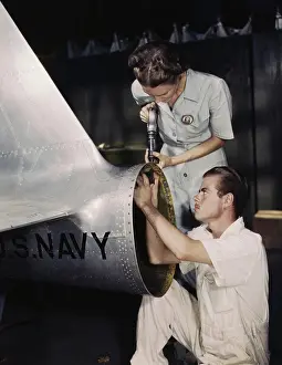 Repairing: A riveter supervises a NYA trainee at a U.S