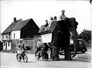 Flaps: Robot elephant walking along a road, with passengers