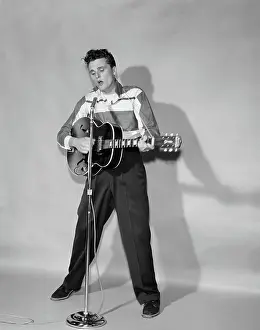Crs001: Rockabilly singer in front of microphone strumming