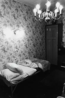 Unmade: Room with unmade bed and patterned wallpaper