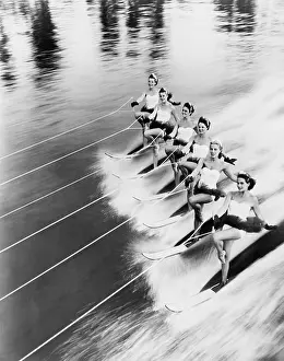 Coordinate: Row of women water skiing