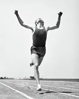 Exertion: Runner Straining to Break Tape at Finish of Race