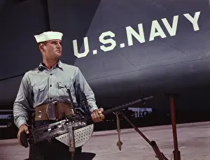 Bombardier: Sailor holding a.30-caliber machine gun in