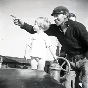 Peaked: Sailor and small child at the ship's wheel