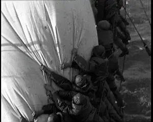 Washed: Sailors Hanging On To A Sail on a Large Sailing