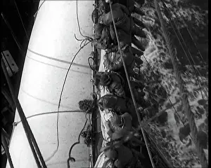 Washed: Sailors Hanging On To A Sail on a Large Sailing