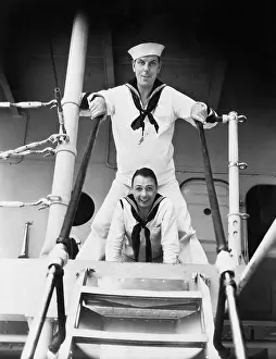 Straddling: Two sailors standing on a gangway