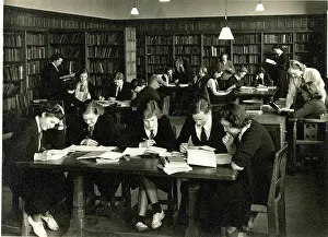 Studious: Schoolgirls in uniform studying in a library