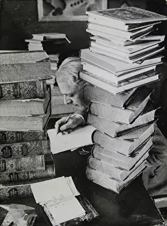 Encyclopedias: A scientist sits surrounded by piles