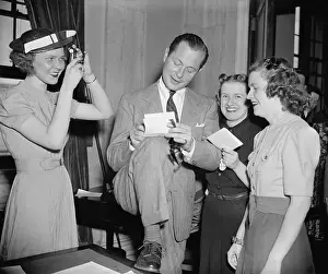 Autographing: Screen actor Robert Montgomery, autographing for