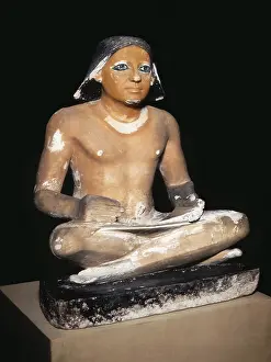 Misr: Scribe seated cross-legged holding a papyrus