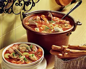 Clams: Seafood Stew in Copper Pot with Breadsticks alongside