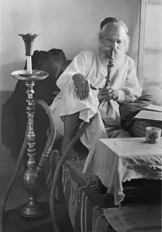 Nargile: Seated man smoking a nargile, or water pipe, ?