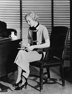Dictating: Secretary at her office desk taking notes