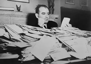 Cold War: Sen. Joseph R. McCarthy sits at desk piled high