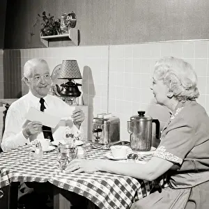 Oldsters: Senior Couple Sitting at Kitchen Table Having