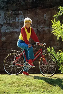 Sneaker: Senior woman on bicycle standing still looking