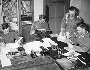 Orderly: A sergeant gives documents to workers in an orderly room