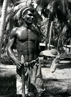 Clothed: Seychelles islander splitting coconut husks