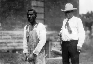 Sheriff: Sherrif carries a colored prisoners on a chain, 1933