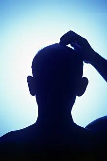 Perplexed: Silhouette bald man scratching his head