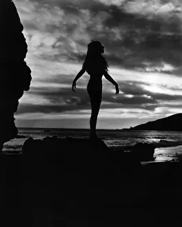 Cloudscape: Silhouette of woman at beach