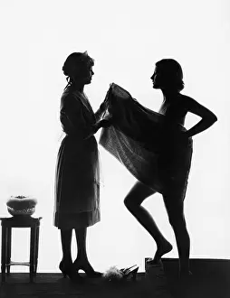 Aiding: Silhouette of two women with a bath towel