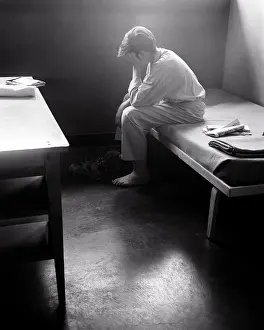 Disadvantaged: Single Boy Sitting on Dormitory Cot Orphanage