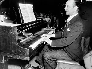 Choral: Sir Malcolm Sargent, conductor, playing piano in a concert