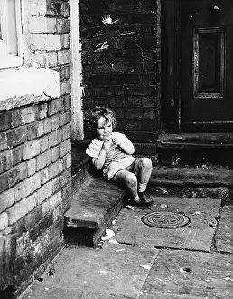 Drain: Small child sitting in a doorway
