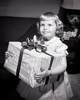 Deb001: Smiling Blond Girl Looking at Camera Holding Large