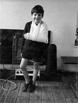 Smiling boy with broken arm in a sling