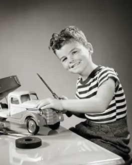 Screwdriver: Smiling Boy looking at Camera Playing with Toy Truck