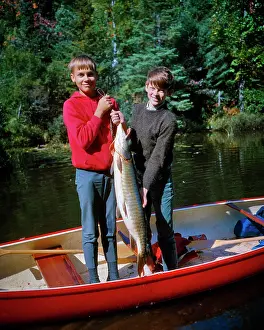 Rewarding: Two Smiling Boys Brothers Standing in Red Canoe