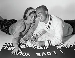 Stomachs: Smiling collegiate couple lying on stomachs with