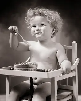 Consume: Smiling Curly Haired Baby Boy Sitting in High