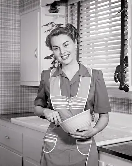 Homemaker: Smiling Housewife in Kitchen Looking at Camera