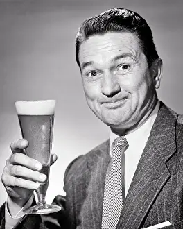 Pilsner: Smiling Man in Jacket and Tie Looking at Camera Hand