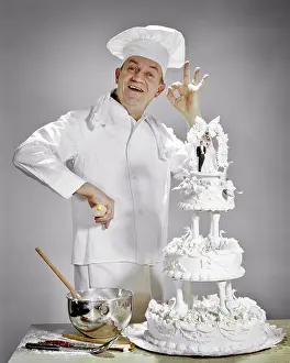 Okay: Smiling Man Pastry Chef Standing by Elaborate Wedding Cake