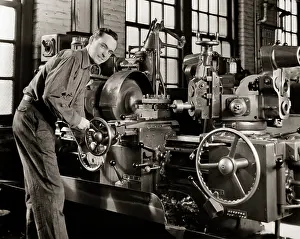 Fabricating: Smiling Man Working a Lathe Machine in a Factory