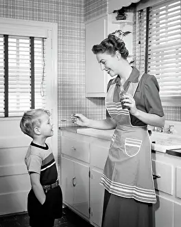 Impairment: Smiling Mother Giving Boy Spoonful