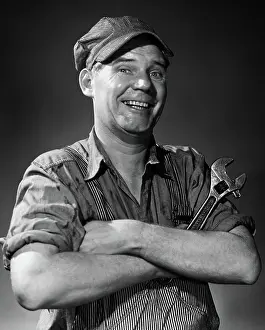 Plumber: Smiling portrait man in striped cap & overalls