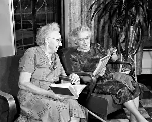 Retiree: Two Smiling Senior Women Sitting Side by Side