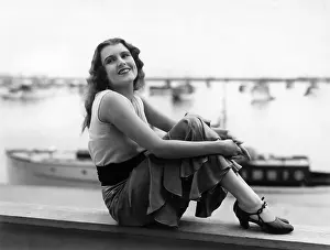 Retaining: Smiling woman posing by sea
