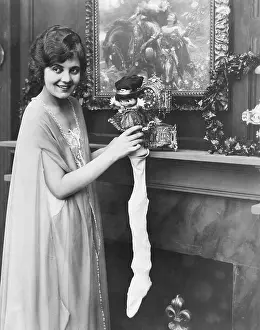 Nightgowns: Smiling woman stuffing Christmas stocking